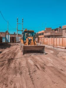 Yellow bulldozer on a construction site under clear blue sky, ready for operation.